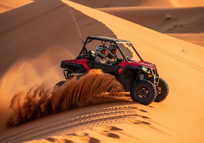 2-seater buggy kicking up sand on a Dubai dune